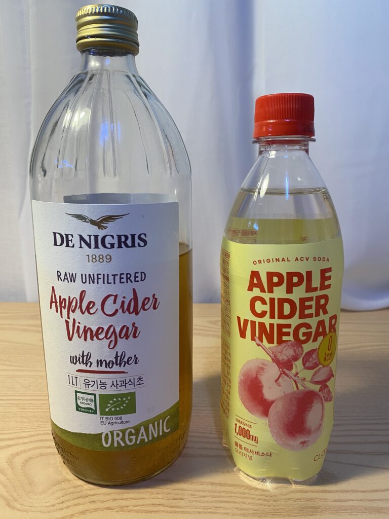 A minimalist setting featuring a glass of diluted apple cider vinegar with cinnamon, illustrating the Korean Biohacking Routine for metabolic health and mental clarity by Bridget June.