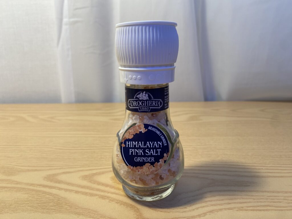 A premium glass of warm Himalayan pink salt water as a morning biohacking ritual for mental clarity and electrolyte balance by Bridget June.