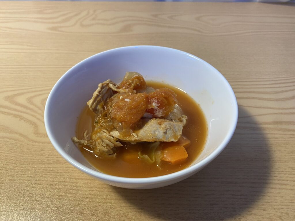 양배추, 브로콜리, 토마토가 듬뿍 들어간 브리짓 준의 항염 마녀스프. 세포 재생과 전신 해독을 위한 바이오해킹 식단을 상징하는 이미지.