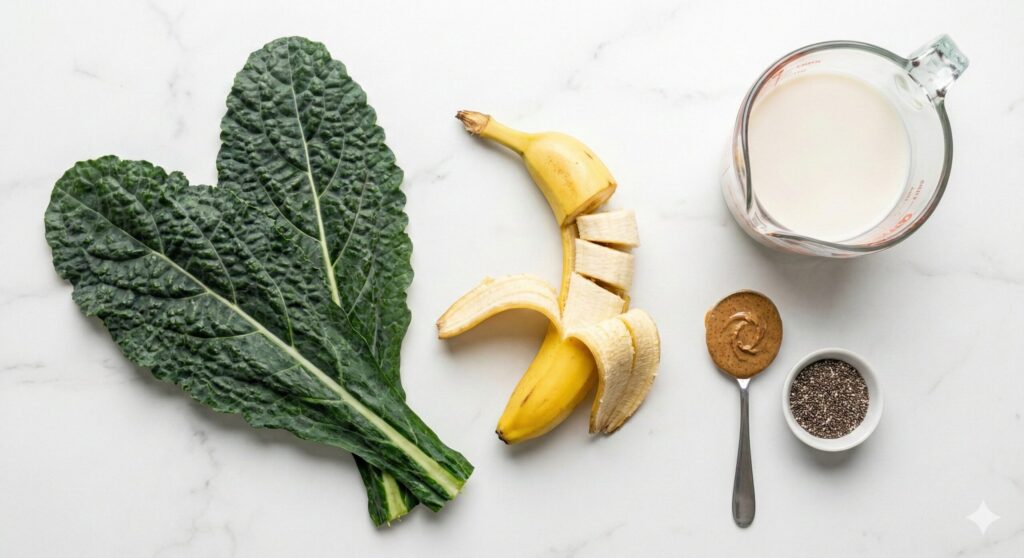 신선한 케일, 잘 익은 바나나, 아몬드 밀크, 아몬드 버터 등 케일 바나나 스무디 레시피를 위해 정확히 계량된 원재료 모음.