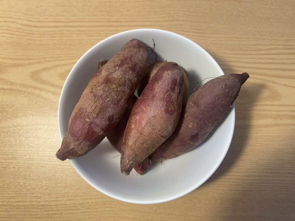 Fresh sweet potatoes with antioxidant-rich purple skins, a staple carbohydrate source for the biohacking diet.