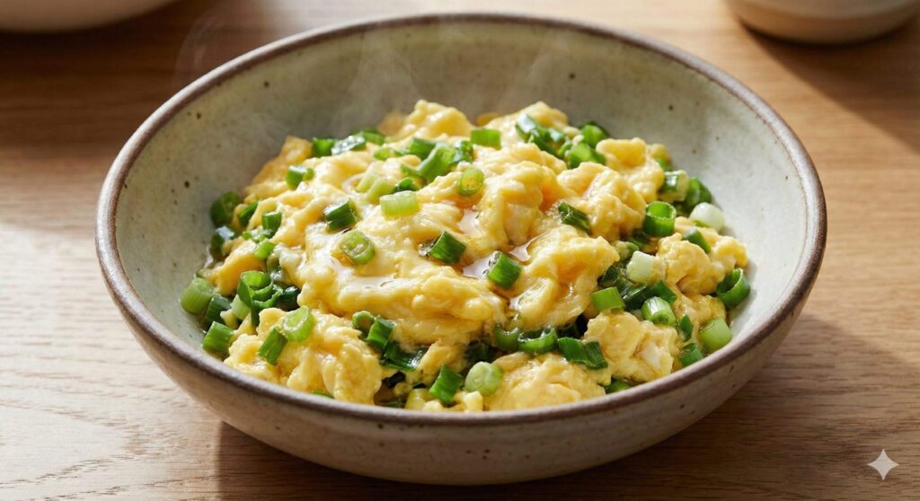 A close-up of a finished Scallion & Egg Stir-Fry with soft, fluffy scrambled eggs and generous amounts of green scallions, ready to boost immunity.