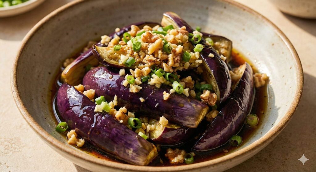 Plated steamed eggplant tossed in perilla oil and soy sauce, garnished with crushed walnuts for brain and artery health.