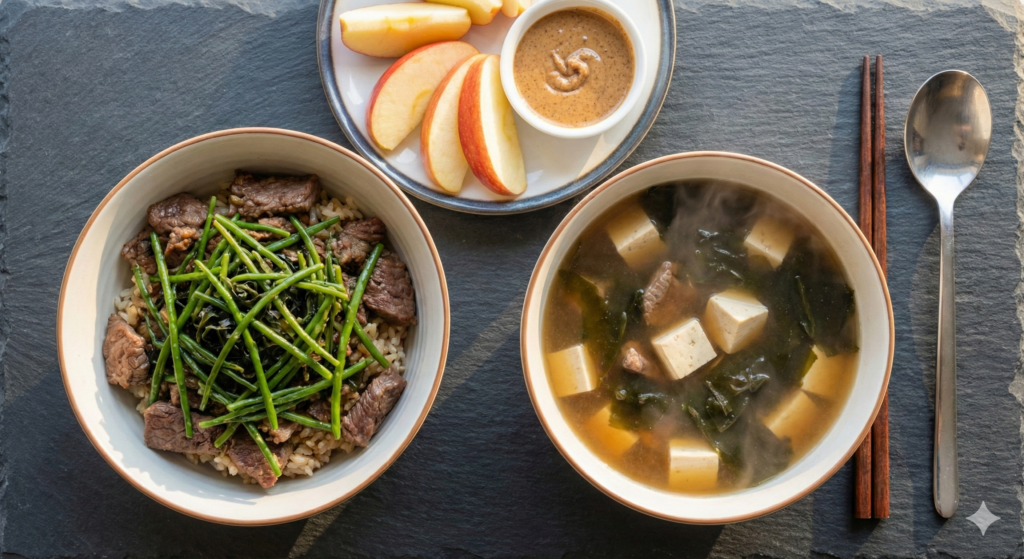 A beautiful overhead spread of Day 41 biohacking meals featuring Stir-fried Seaweed Stems with a Beef Rice Bowl, a snack of sliced apple with almond butter, and a comforting bowl of Beef Seaweed Soup with Tofu.