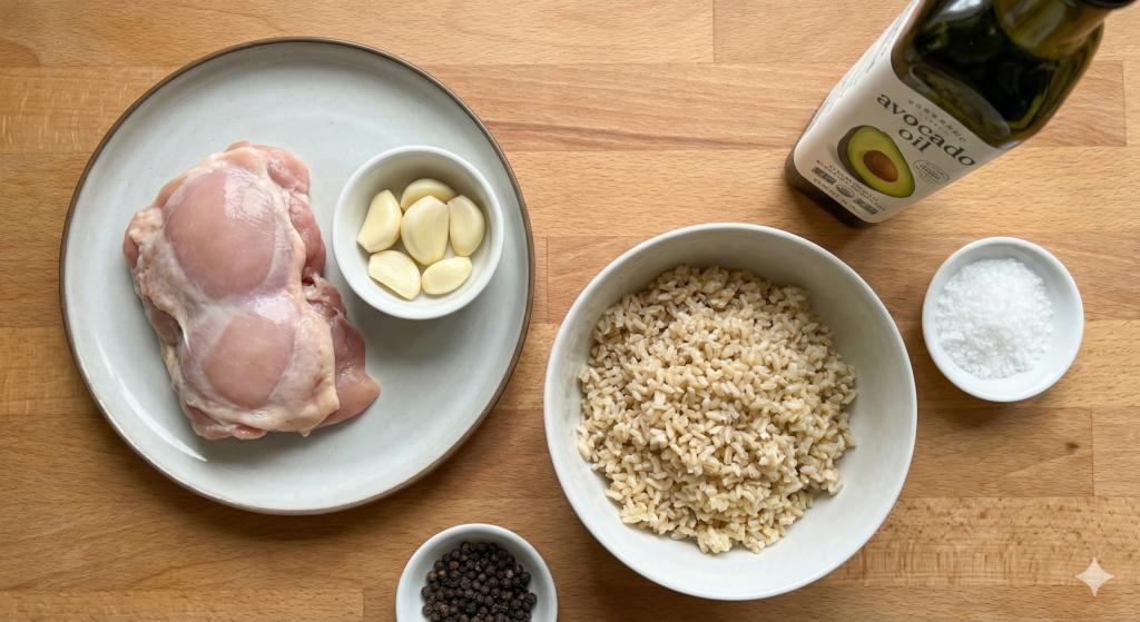 High-performance biohacking ingredients: a deboned raw chicken thigh rich in zinc, a handful of whole peeled garlic cloves, cooked and cooled brown rice for resistant starch, avocado oil, sea salt, and black peppercorns.